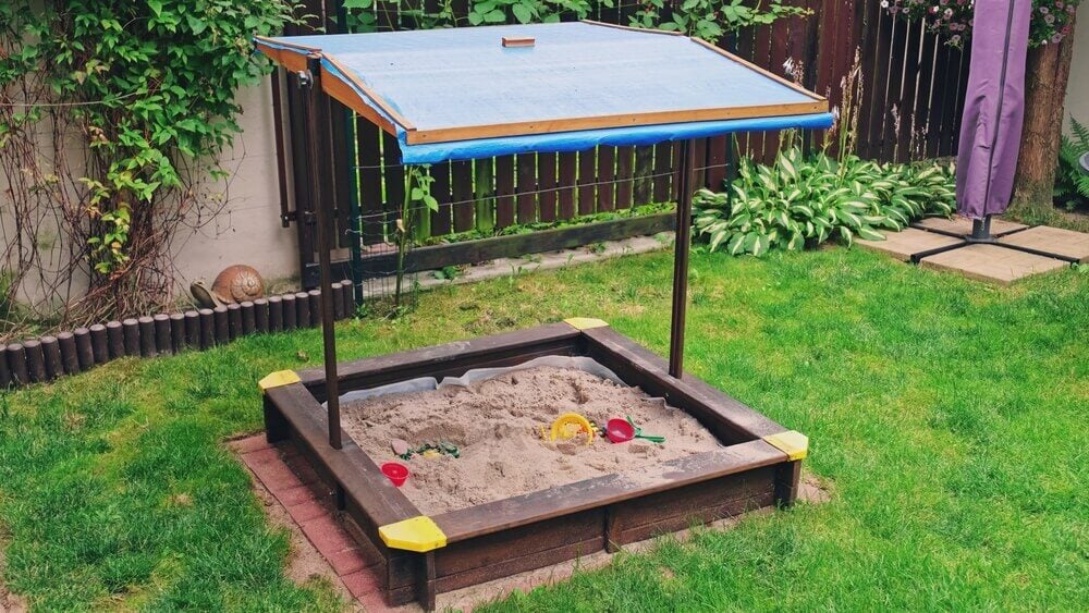 backyard sandbox playground with nifty blue canopy