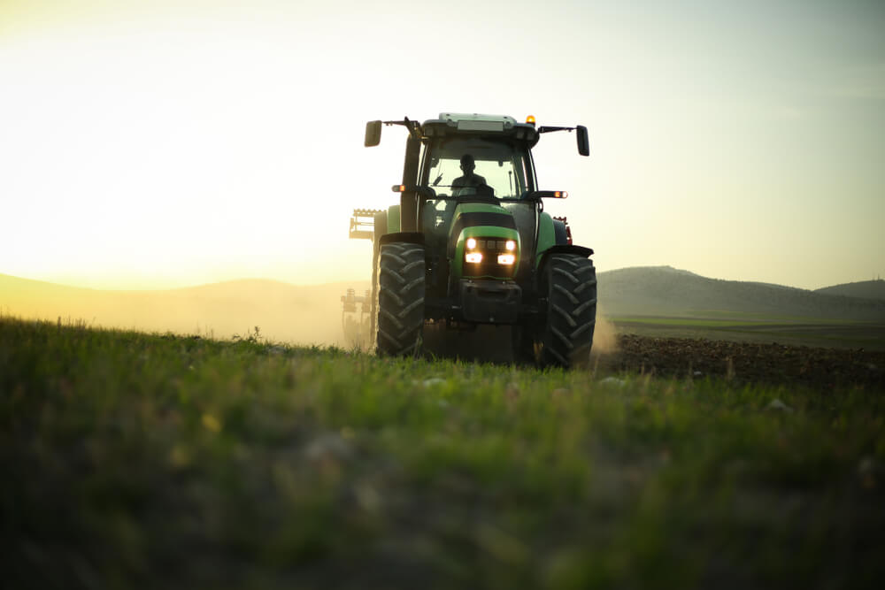 driving the utility tractor and trying to finish the farm work before the sun sets