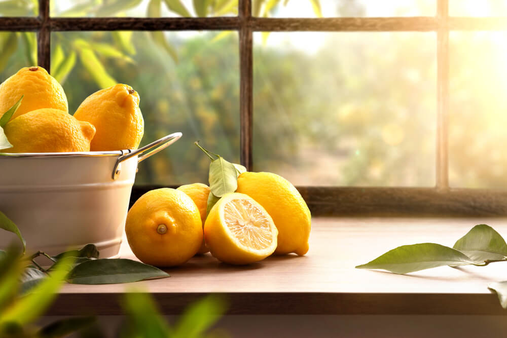 Basket stuffed with fresh lemons on a window.