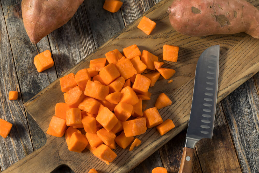Fresh organic orange sweet potatoes sliced into cubes.