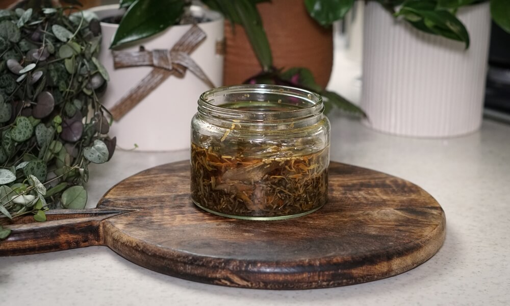 Lovely garden herbs infusing a small jar of vinegar for epic home cooking.
