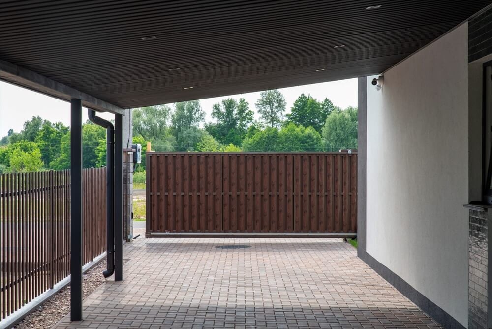 A backyard patio with a fancy canopy and brick paving.
