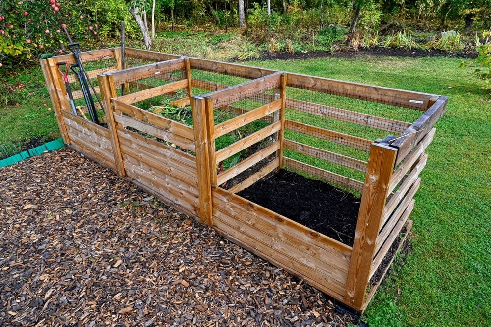 A garden compost bin with three compartments for making epic organic fertilizer.