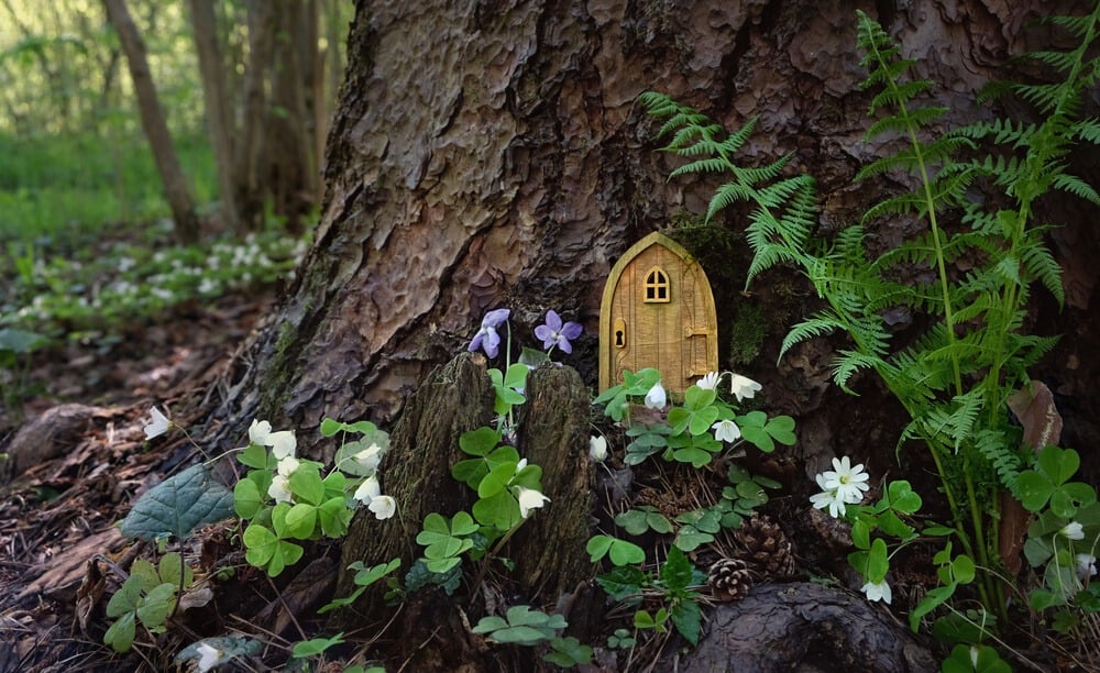 Lovely fairy tale tree house with a tiny adorable fairy door on a tree.