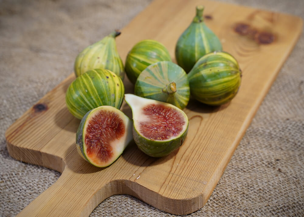 Yummy tiger figs also known as panache figs resting on a cutting board.