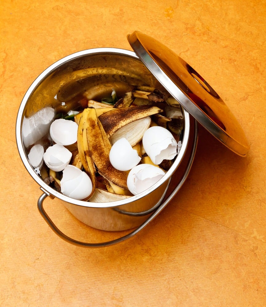 Compost bucket with egg shells and banana peels.