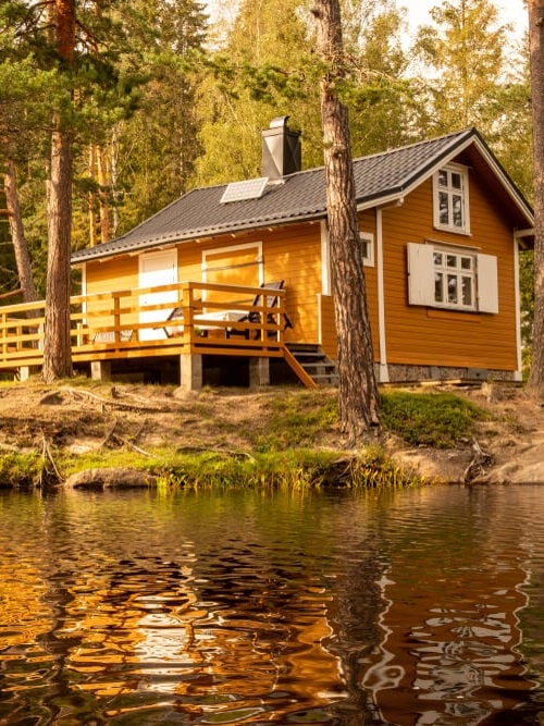 cabin in the woods next to a lake powered by solar energy